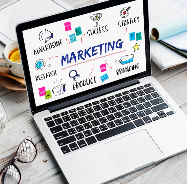 The word "marketing" on a laptop screen and a mind-map to illustrate what marketing is